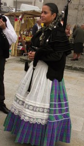 Soort doedelzakspeelster die voor de processie loopt